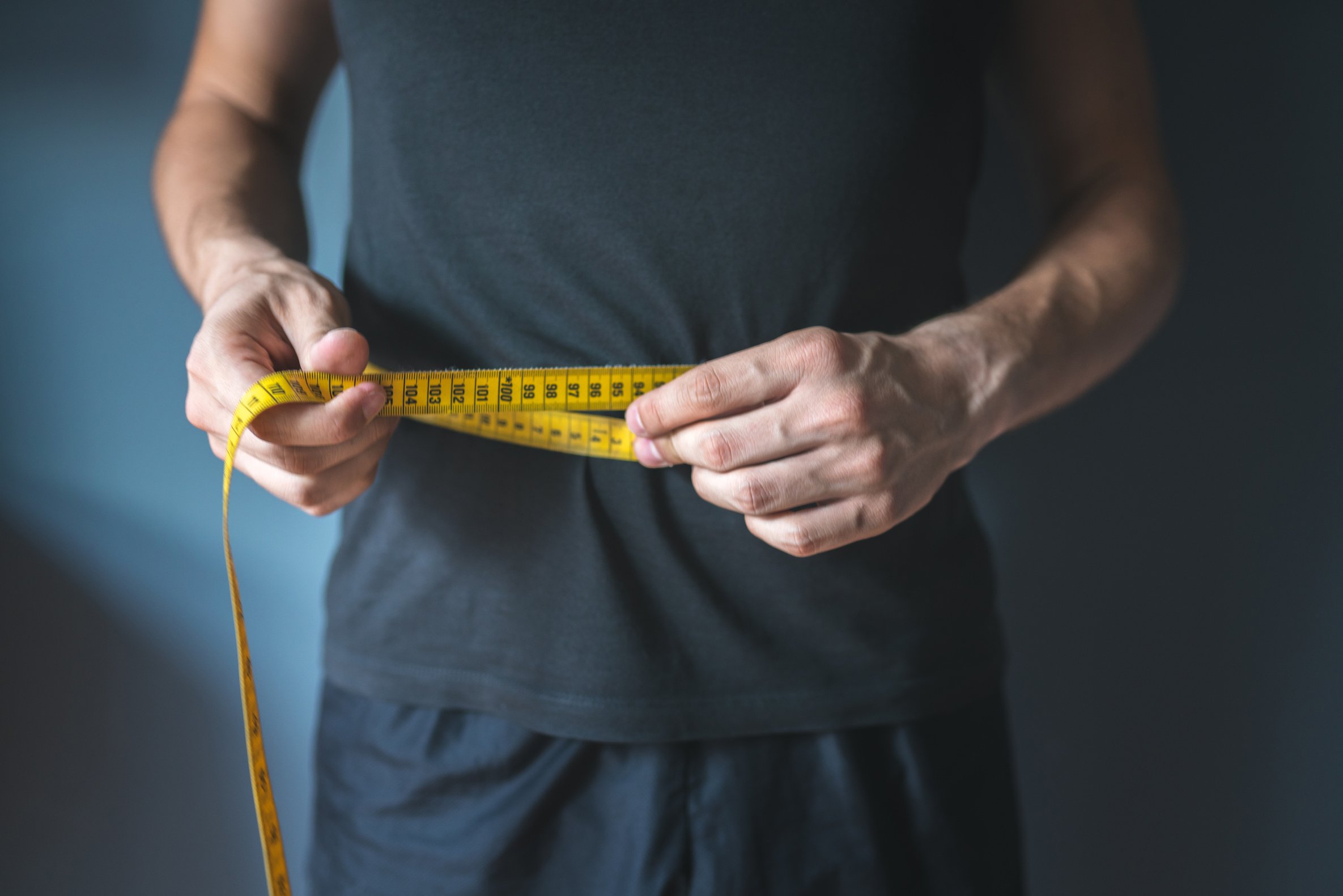 Slim Person Measuring Waist with Tape Measure